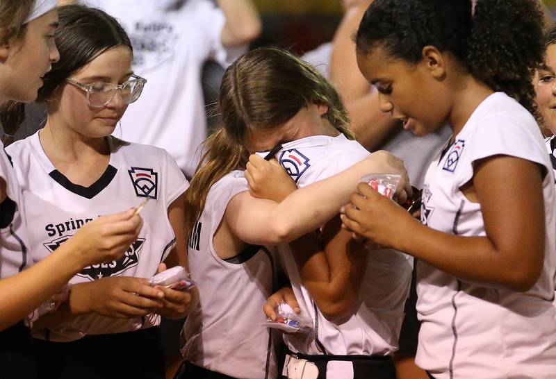 Eleanor Simpson (center) reacts with tears of joy while her teammates comfort her after winning the Minor League Softball State title over Evergreen Park on Thursday, July 27, 2023 at St. Mary's Park in La Salle.