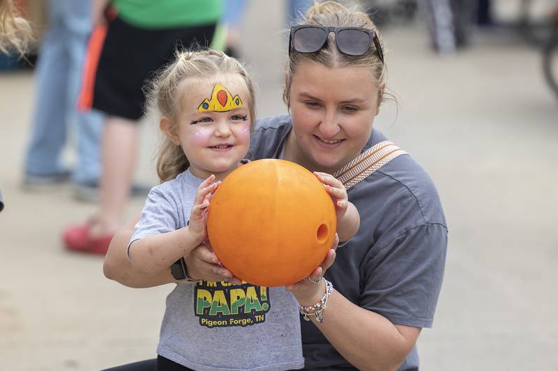 Isla Groom, 2, helps mom Anni with a little pumpkin bowling Saturday, Oct. 18, 2025, during Discover Dixon’s Scarecrow Fest.