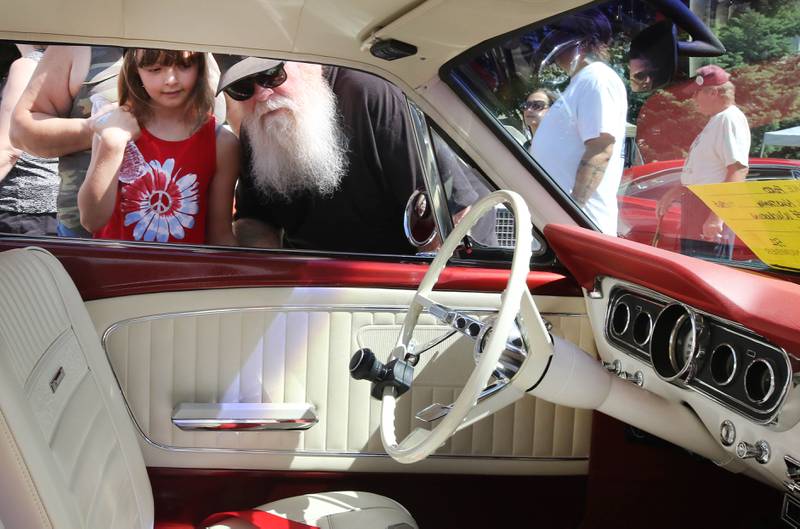 Haylee Grove, 10, and her Grandpa Wayne Ecklund, from Lombard, check out the interior of a classic Mustang on State Street during the Fizz Ehrler Memorial Turning Back Time Car Show Sunday, July 30, 2023, in downtown Sycamore.