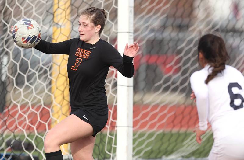 DeKalb’s Isabella Schmerbach tries to kick the ball away from her goal as Belvidere North’s Keyla Suarez charges hard during their game Wednesday, March 15, 2023, at DeKalb High School.