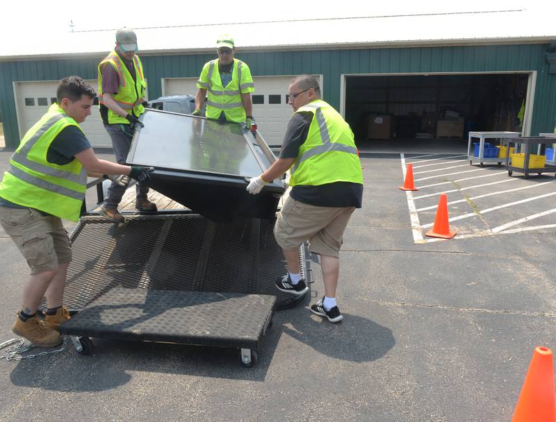 Volunteers unload a very large big screen television during the electronics recycling event conducted by the Ogle County Solid Waste Management Department on Friday, June 23. The residential recycling program is for Ogle County residents only and requires a free permit before dropping items off.
