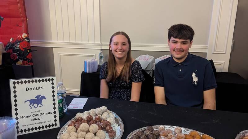 Edie Mareci of Minooka, a member of Shorewood Junior HUGS, and Erik Del Toro of Shorewood, oversee the Home Cut Donuts table  at the Shorewood HUGS annual chocolate ball on Saturday, February 1, 2025, in joliet.
