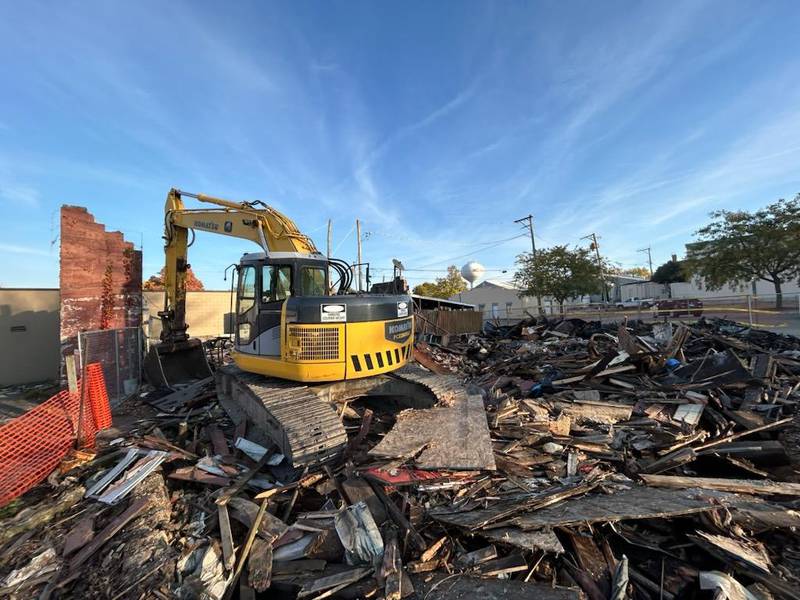 An excavator demolished the two buildings at the corner of Wesley Avenue and Main Street, on Monday, Oct. 21, 2024, in downtown Mt. Morris. The buildings were destroyed in an April fire.