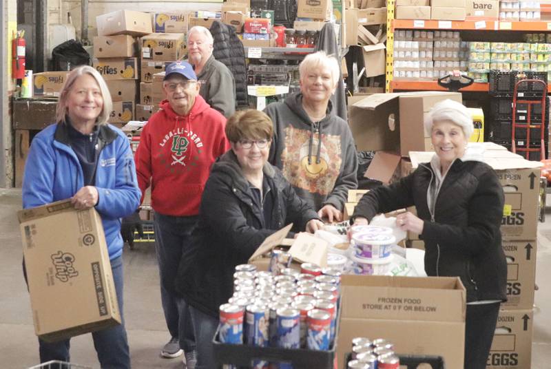 Volunteers gather perishable food during the Thanksgiving distribution on Wednesday, Nov. 19, 2025 at the Hall Township Food Pantry in Spring Valley. Nearly 500 families will receive food from this years distribution.
