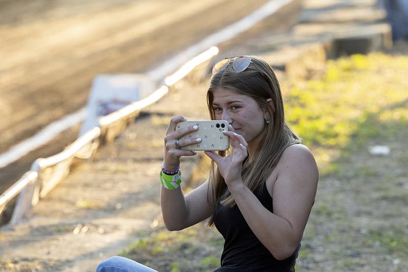 Ashley McDonald smiles while videoing dad Tony McDonald compete Wednesday, Aug. 7, 2024, in the Carroll County Fair Badger State Tractor Pulls. McDonald won his class for the night.