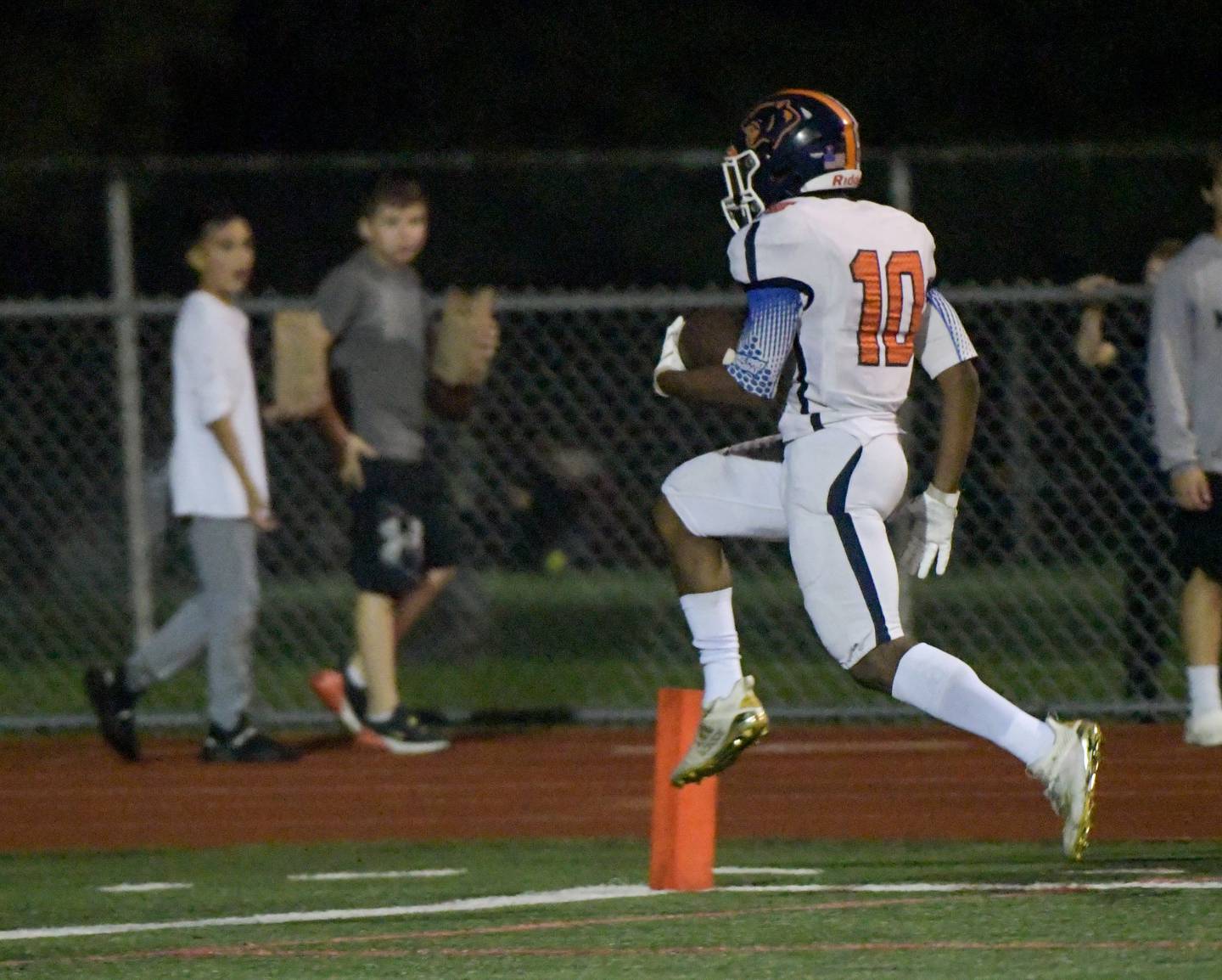 Oswego's Tyler Weddington (10) leaps into the end zone for a fourth quarter touchdown against West Aurora during a game in Aurora on Friday, October 8, 2021.