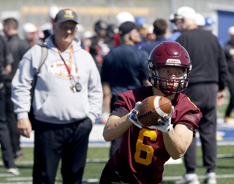 Richmond-Burton's Hunter Carley catches a toss as his coach Mike Noll watches at the Northern Burbs Football Showcase on Monday, May 4, 2026, at Johnsburg High School. Over 165 players from 15 teams demonstrated their football skills to over 60 college coaches.