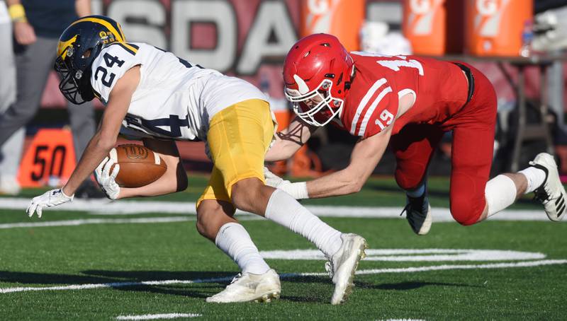 Glenbrook South's Tommy MacPherson, left, gets tackled by Hinsdale Central's Nick Fahy during the second round of the Class 8A high school football playoffs in Hinsdale Saturday.
