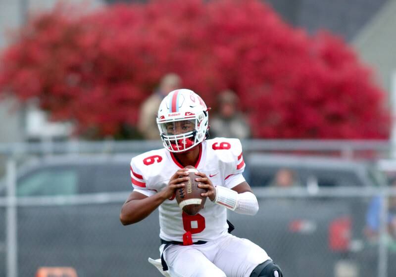 Ottawa’s quarterback Colby Mortenson looks for an option in varsity football at Larry Dale Field on the campus of Woodstock High School Saturday.