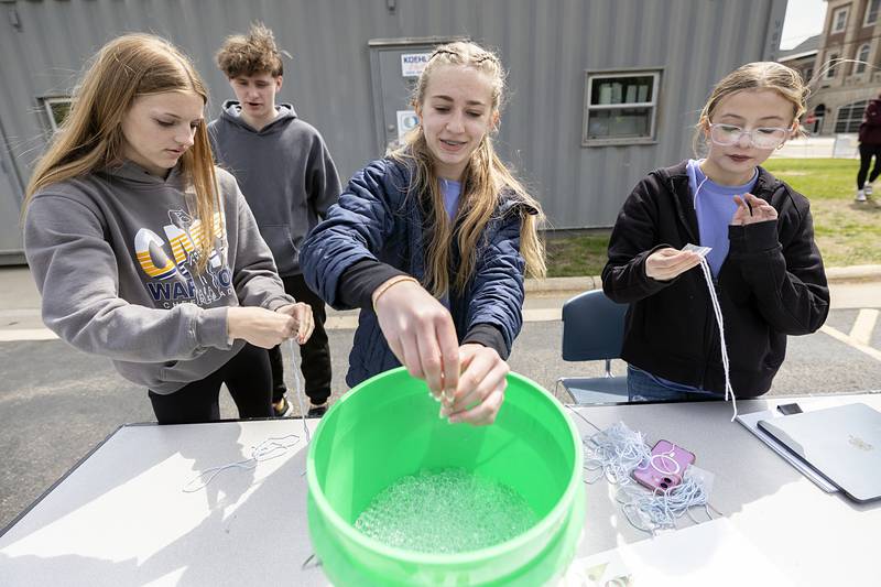 Ily Sheldon (left), Sophia Davis and Addison Nichols prepare seed packs with Orbeez on Thursday, May 7, 2026, during Sterling High School’s Farmapalooza.