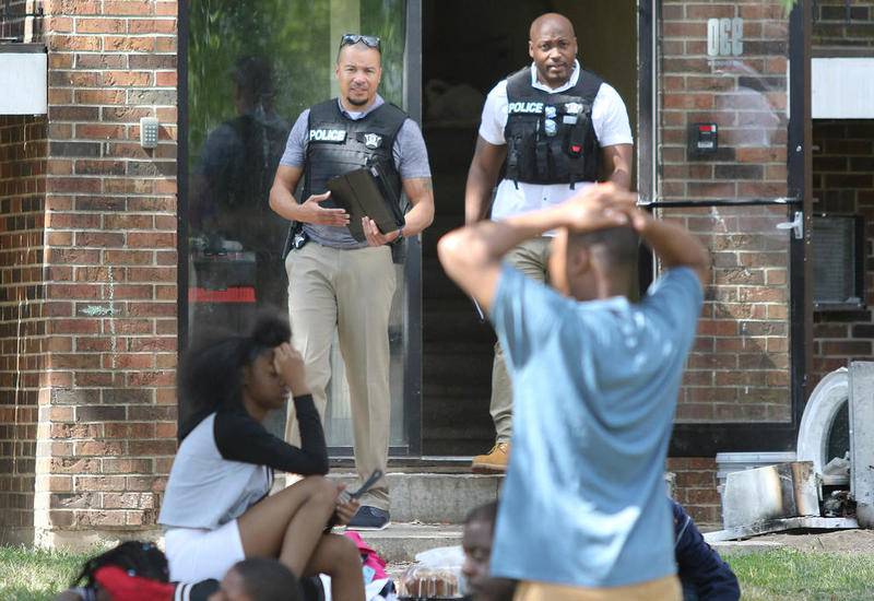 Displaced residents show their exhaustion as two Northern Illinois University Police officers exit a building at 930 Greenbrier Road in DeKalb last Thursday after a suspicious morning fire at the location. This building is owned by Hunter Properties who also own Ridgebrook Apartments where a fire that occurred Tuesday night is under investigation.