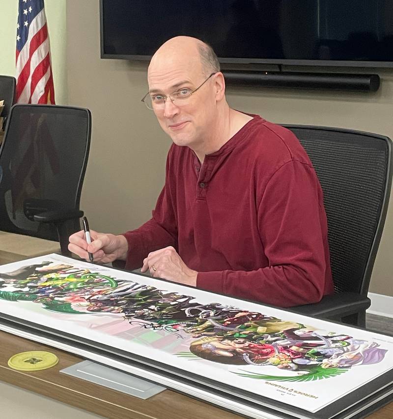 Artist Alex Ross signs his artwork that will be sold in the gift shop at the Dunn Museum in Libertyville.