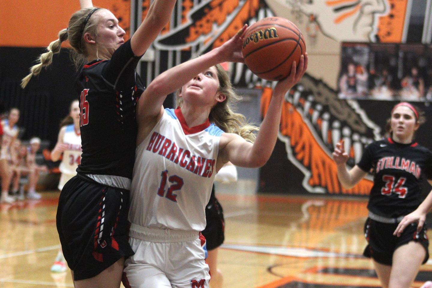 Marian Central’s Madison Kenyon works under the hoop as Stillman Valley’s Taylor Davidson, left, defends in IHSA Class 2A Sectional girls basketball action at Winnebago Tuesday night.