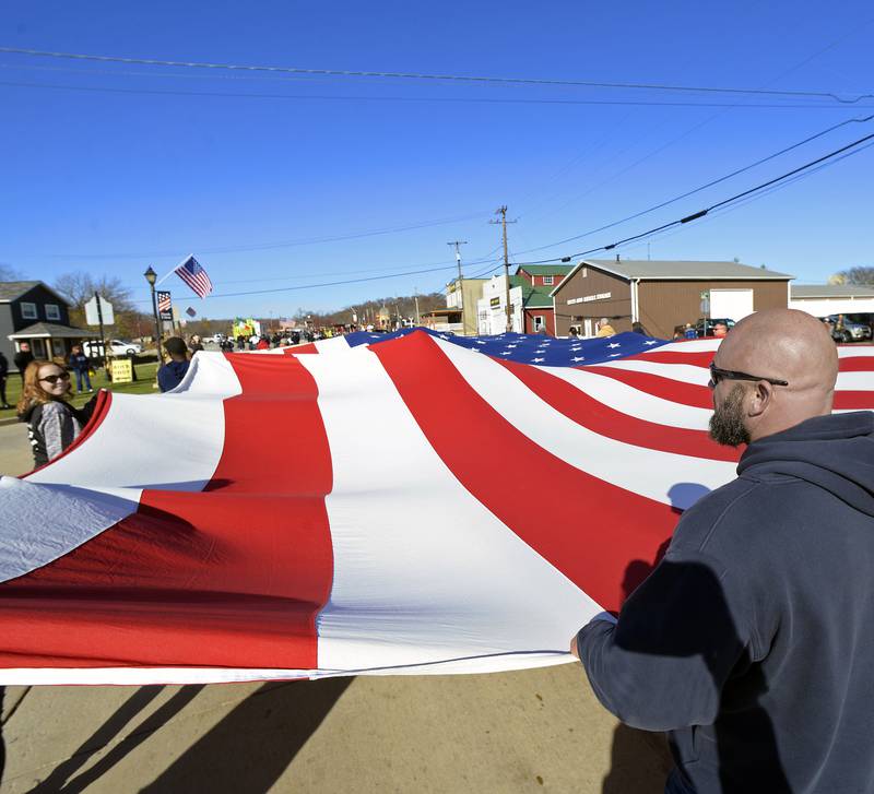 Local Laborers 393 carry a large American flag Sunday, Nov. 6, 2022, along Mill Street during the Utica Veterans Day Parade and Air Show in Utica.