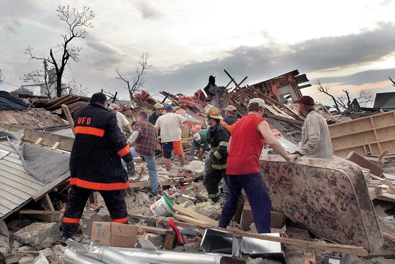 Volunteers and emergency personell dig through the rubbel of the Milestone Tap looking for victims of the tornado on Tuesday, April 20, 2004.