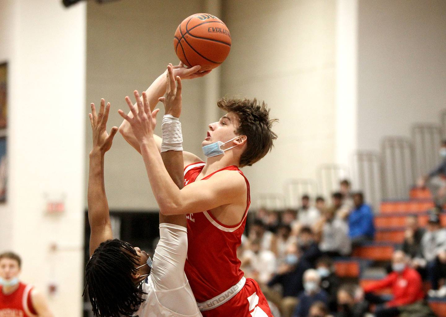 Hinsdale Central's Ben Oosterbaan (right) goes up for a shot over Oswego East's Patrick Robinson during a 15th Annual Hoops for Healing Boys Basketball Tournament game at Naperville North High School on Tuesday, Nov. 23, 2021.