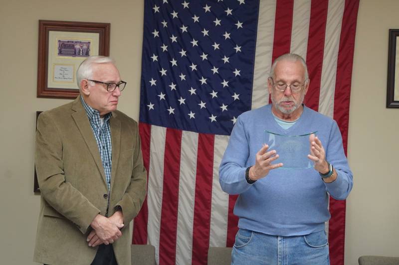 Creston Village President Tom Byro (right) presents longtime Village Attorney Dave Tess with an award at the village's meeting Tuesday, Dec. 2, 2025. The meeting was Tess's last as village attorney after 27 years.