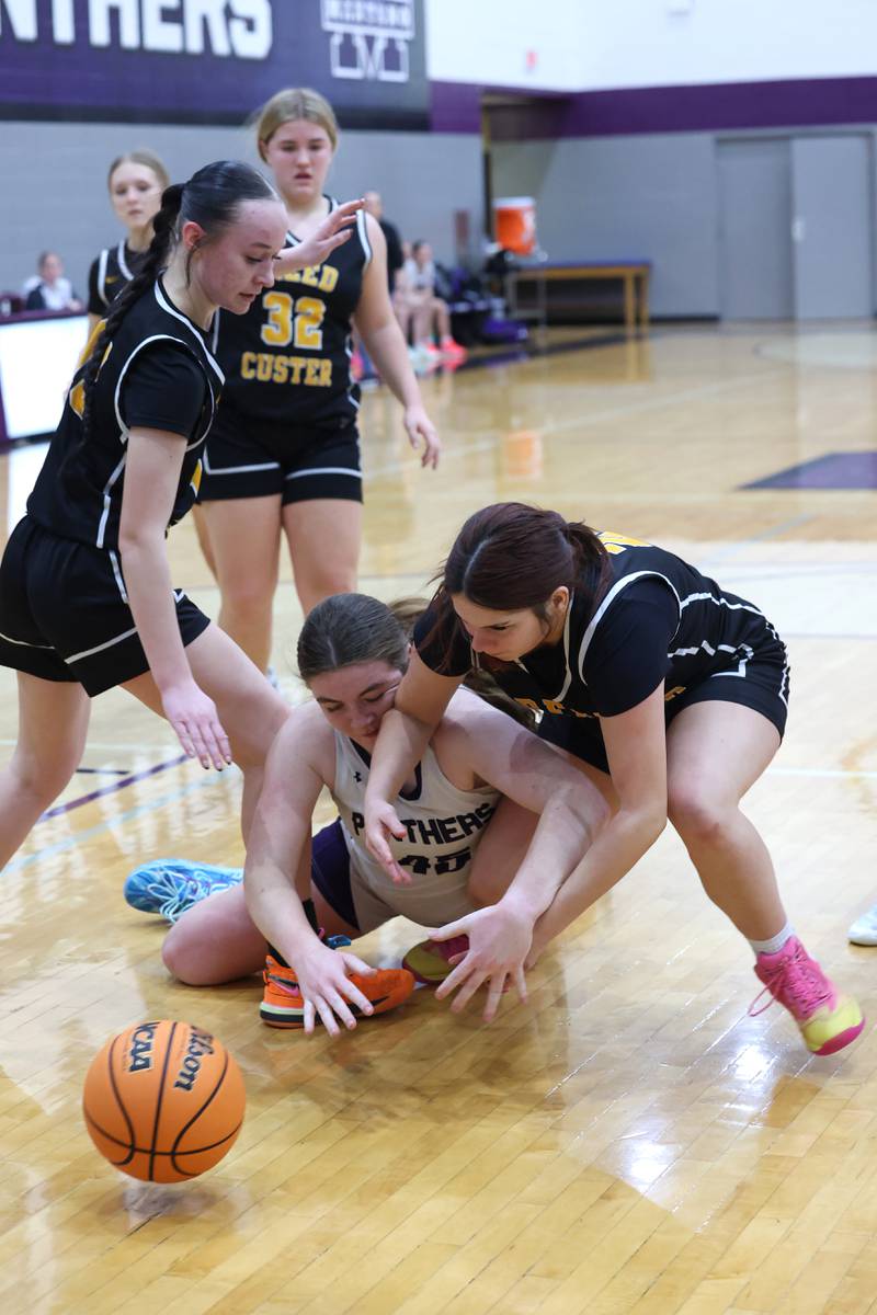Manteno's Emily Horath, center, and Reed-Custer's Brooklyn Gonzalez dive for a loose ball during Reed-Custer's 45-42 victory over Manteno on Monday, Feb. 2, 2026.