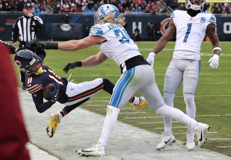Chicago Bears wide receiver Darnell Mooney is hit late out-of-bounds by Detroit Lions linebacker Alex Anzalone during their game Sunday, Dec. 10, 2023 at Soldier Field in Chicago. Anzalone was penalized for unnecessary roughness on the play.