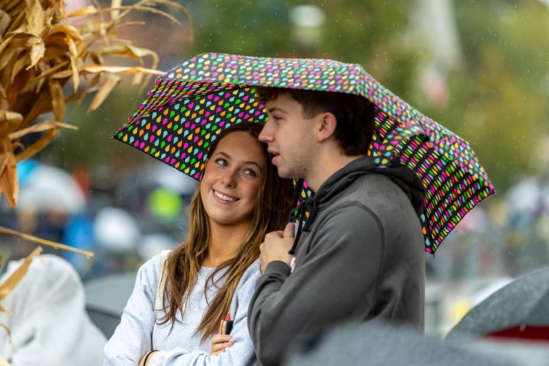 Plainfield residents Anastyn Curry and Zach Bridges share an umbrella while watching the Plainfield Community Homecoming Parade on Sept. 28, 2024.