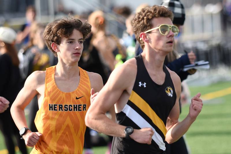 Herscher's Evan Benoit, left, and Jeremy Szepelak run the 3,200 meters at the Herscher Invite Friday, May 1, 2026.