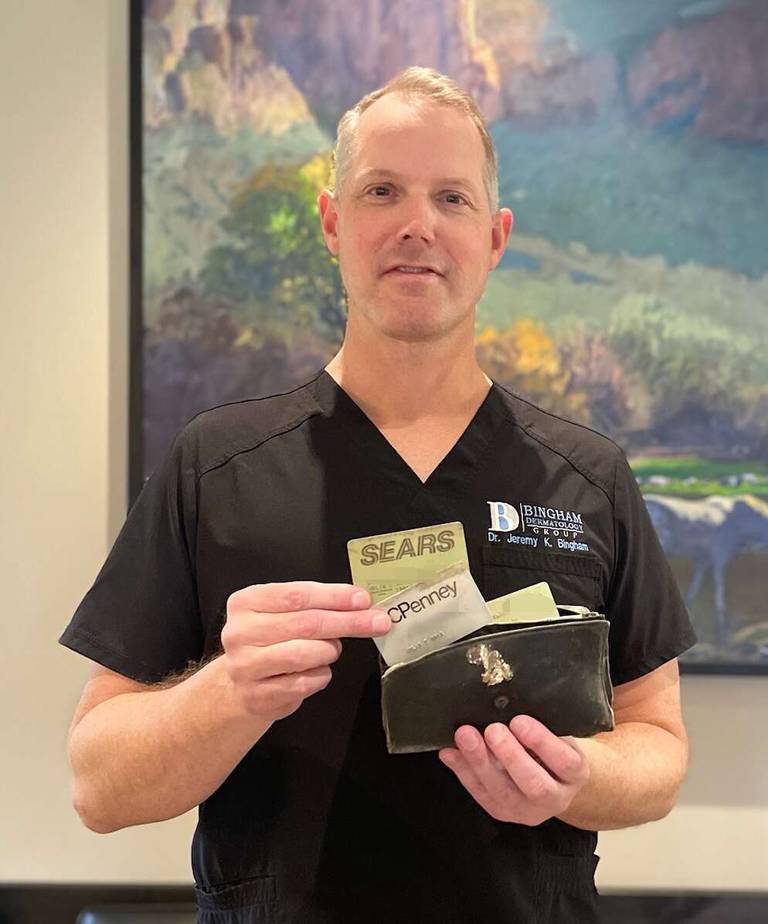 Dr. Jeremy Bingham of Mesa, Arizona, with the wallet that Campton Hills resident Julia Hsia lost in 1995.