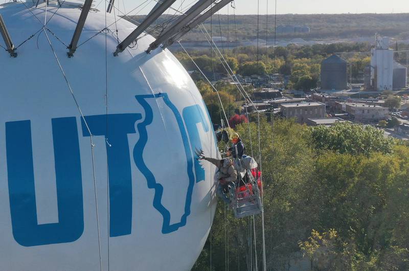 Crews paint a Bald Eagle on top of the Utica water tower on Friday, Oct. 18, 2024 on top of Clarks Hill in Utica. The Village gave the approval to paint the tower and also conduct repairs inside and out. A Bald Eagle and the State of Illinois is featured on the tower.