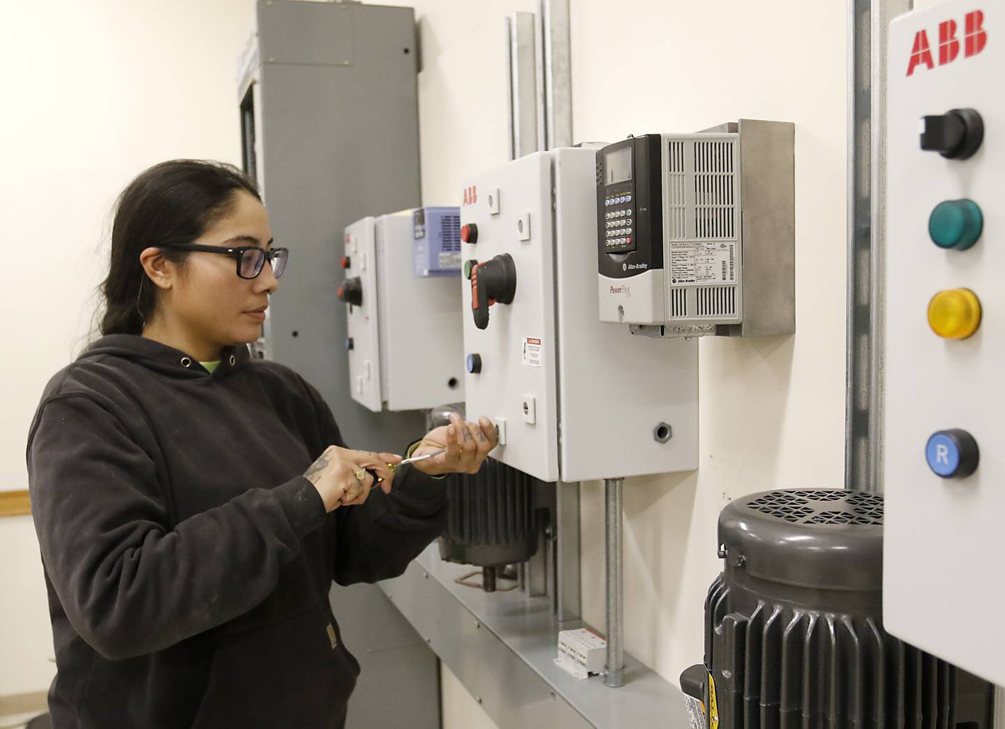 Kassandra Lopez opens an electrical box on Monday, Dec. 9, 2024, in a training room at International Brotherhood of Electrical Workers Local 117 in Crystal Lake.