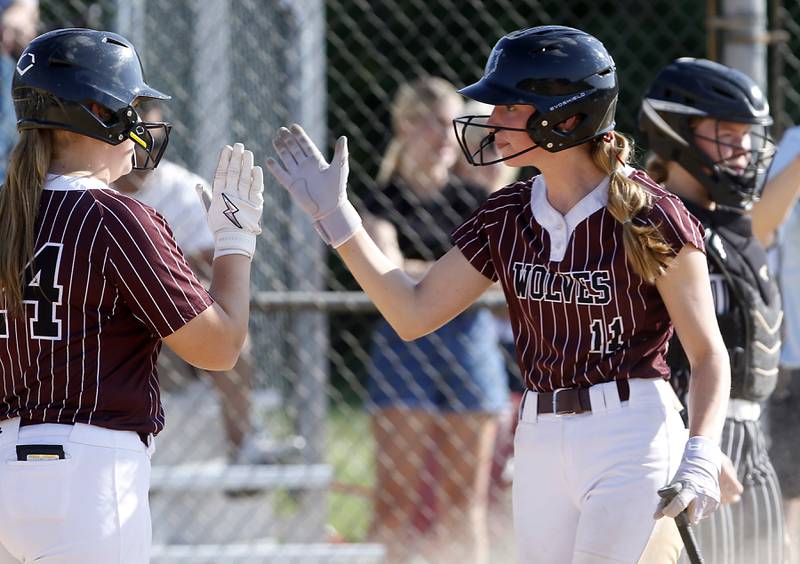 Prairie Ridge's Kendra Carroll (left) celebrates with teammate, Reese Vrba, after scoring a run during a Fox Valley Conference softball game against Crystal Lake Central on Wednesday, May 14, 2025, at Crystal Lake Central High School.