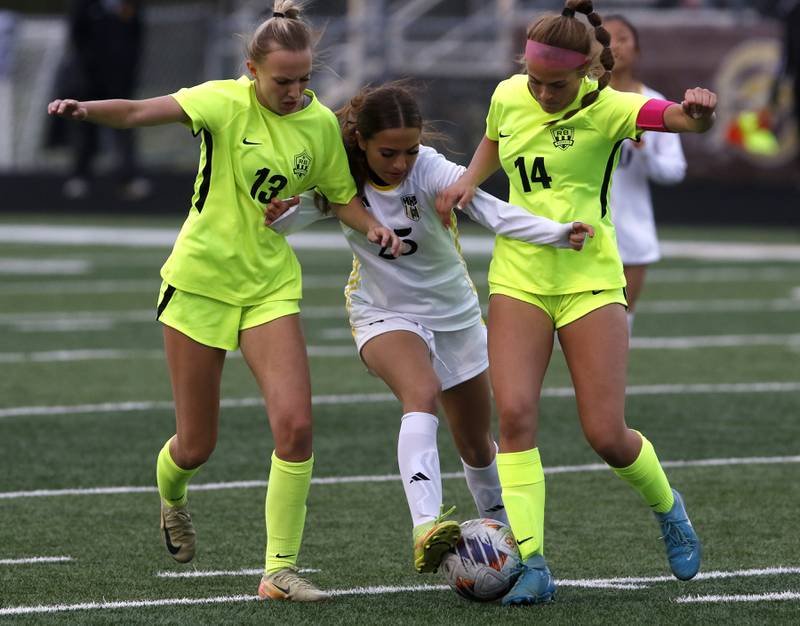 Harvard's Giada Reising tries to control the ball as she is sandwiched between Richmond-Burton's Sydney Frericks, (left) and Addison Sell (right) during the Kishwaukee River Conference Girls Soccer Tournament Championship Match on Wednesday, May 7, 2025, at HRichmond-Burton High School in Richmond.
