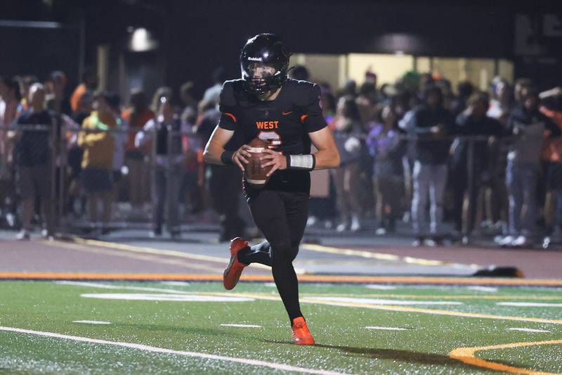 Lincoln-Way West’s Cole Crafton rolls out to pass against Bolingbrook. Sept. 9, 2022, in New Lenox.