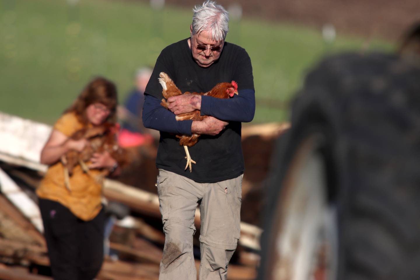 First responders, property owners and volunteers tend the scene of a barn collapse along Weidner Road near Harvard on Tuesday evening, May 7, 2024, helping remove rubble and rescue farm animals who were trapped. At least four animals died.