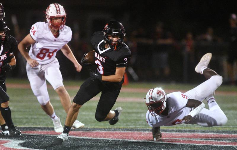 Glenbard East's Gianbiagio Brusca (3) slips past South Elgin's London Leflore (9) during Friday’s football game in Lombard.