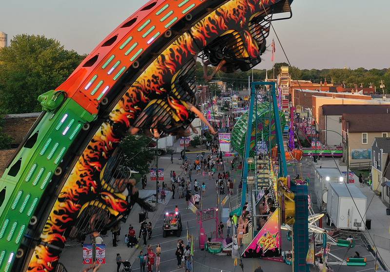 Kids hang upside down while riding the Fireball carnival ride during Spring Valley Summerfest on Thursday, June 19, 2025 downtown Spring Valley. The festival features a carnival, live entertainment, food vendors and fireworks on Saturday at dusk.