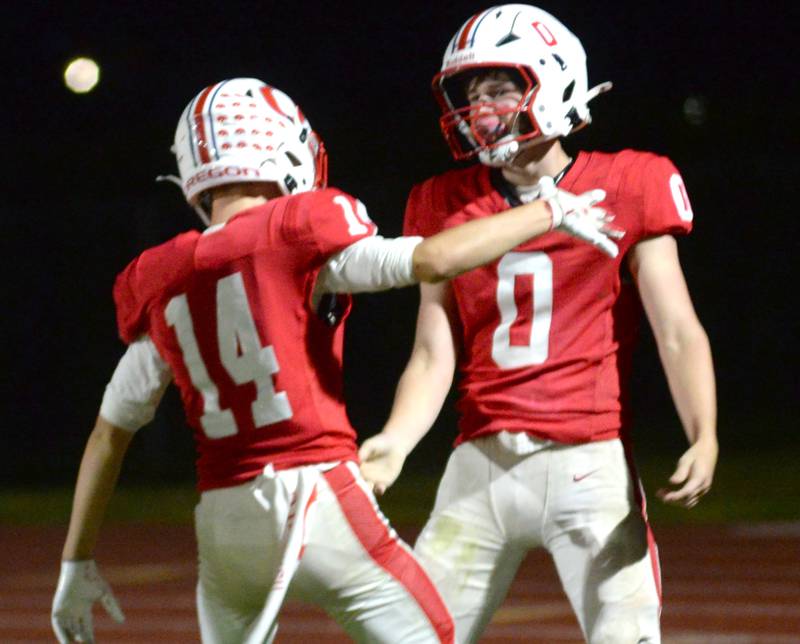 Oregon's Aiden Currier (0) celebrates with Logyn Embick (14) after running a kickoff back for a touchdown against Rock Falls on Friday, Sept. 19, 2025 at Landers-Loomis Field in Oregon.