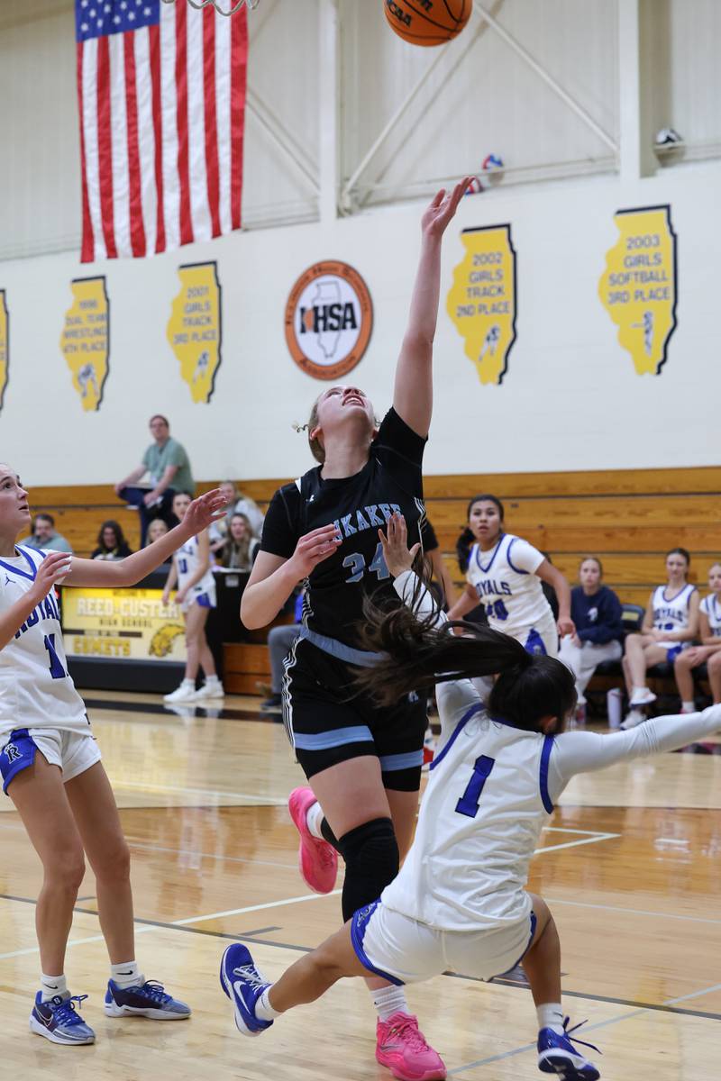 Kankakee's Ava Johnson tosses up a layup as Rosary's Aleah Luna falls to the ground during the Kays' 75-28 victory over Rosary at the Reed-Custer Classic on Monday, Nov. 17, 2025.