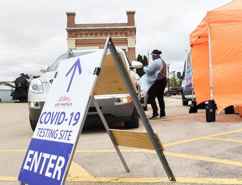 A worker talks with a driver after a COVID-19 test outside of the Amboy Depot Museum on Sept. 29. Aunt Martha's Health and Wellness offered drive-through COVID-19 tests Tuesday in the parking lot from 11 a.m. until 2 p.m.