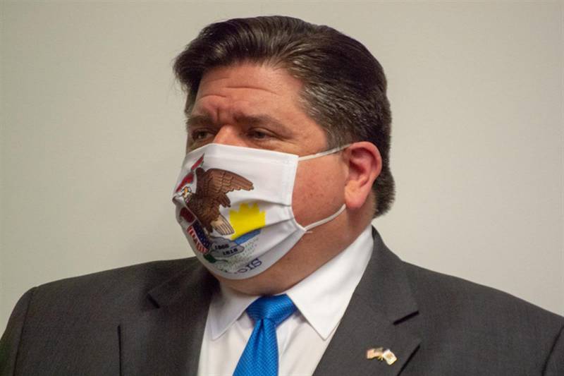 Gov. JB Pritzker is pictured in an Illinois-themed mask during a COVID-19 news conference in Springfield in 2021. He spoke to Capitol News Illinois this week about the upcoming end to the COVID-19 disaster declaration that has been in place for more than three years.