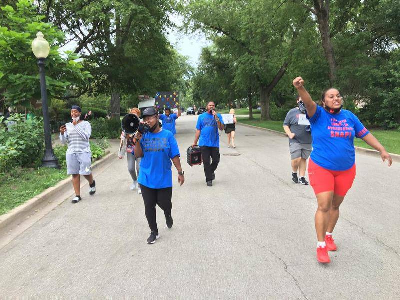 Loretta Hobbs (center), Latasha Simmons (right) and several other protesters march Saturday on Buell Avenue in Joliet while protesting against Mayor Bob O'Dekirk and police misconduct .
