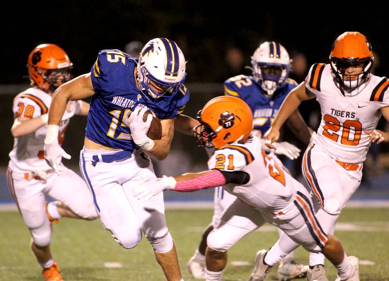 Wheaton North’s Karsten Libby carries the ball before a tackle by Wheaton Warrenville South’s Hunter Almada during a game at Wheaton North on Friday, Oct. 7, 2022.