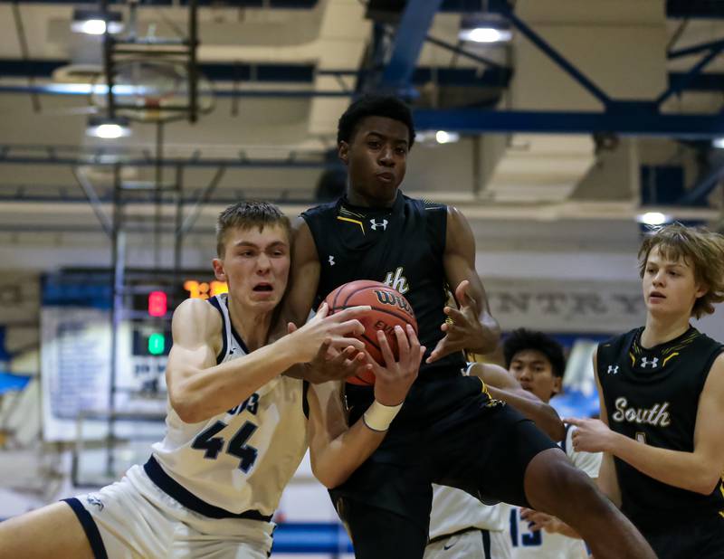 Hinsdale South's Gemarion Alexander (21) battles Downers Grove South's Justin Sveiteris (44) for a rebound during basketball game between Hinsdale South at Downers Grove South. Dec