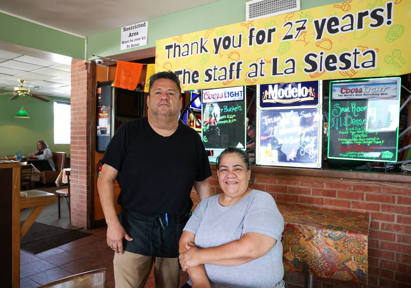 Homero Trevino, left, and Raquel Quirarte, siblings and co-owners of La Siesta in Bradley, pose under a banner near the restaurant's entrance thanking the community for 27 years of business. The longtime Bradley business will be open for one more week, holding a community party on Friday, Aug. 8, and a final day of operation on Saturday, Aug. 9.