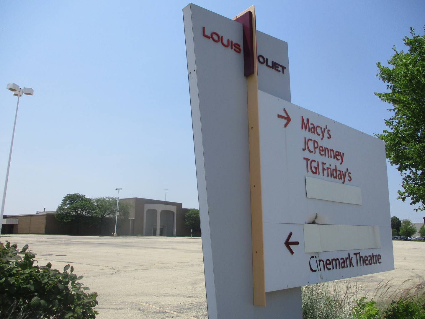 A sign outside the closed Sears store at Louis Joliet Mall in Joliet points visitors to mall attractions with the names of the two closed anchor stores covered up. June 11, 2025