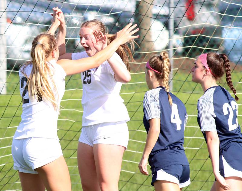 Prairie Ridge’s Anna Mertel, center, celebrates her goal with teammate Adella Pollack, left,  in varsity girls soccer at Cary-Grove High School in Cary on Tuesday, April 29, 2025.