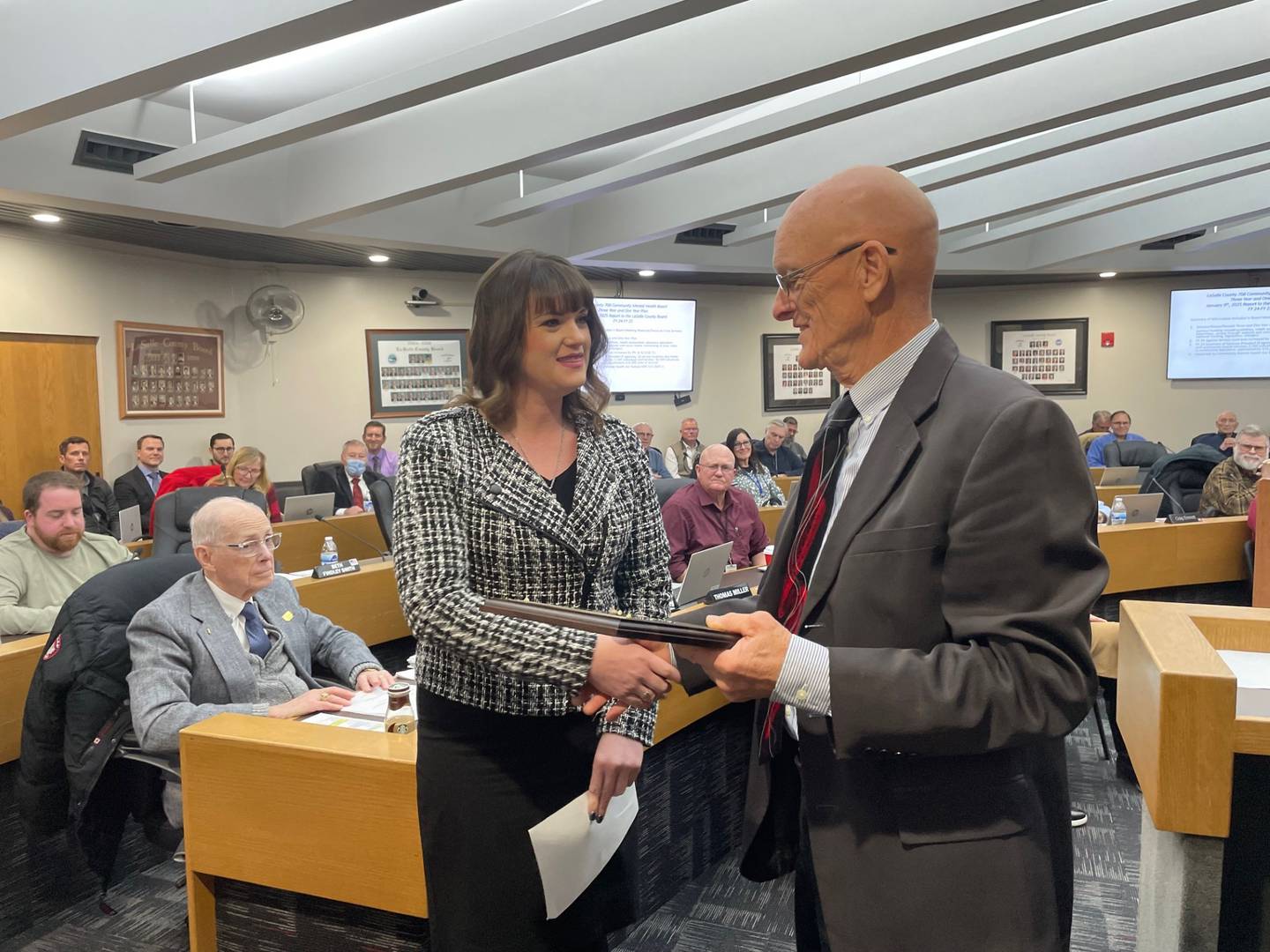 Beth Findley Smith, outgoing La Salle County Board member, accepts a congratulatory plaque from Chairman Don Jensen (R-Deer Park) at the Thursday, Jan. 9, 2025, board meeting in Ottawa. The Somonauk Republican moved from her district and had to vacate her seat.