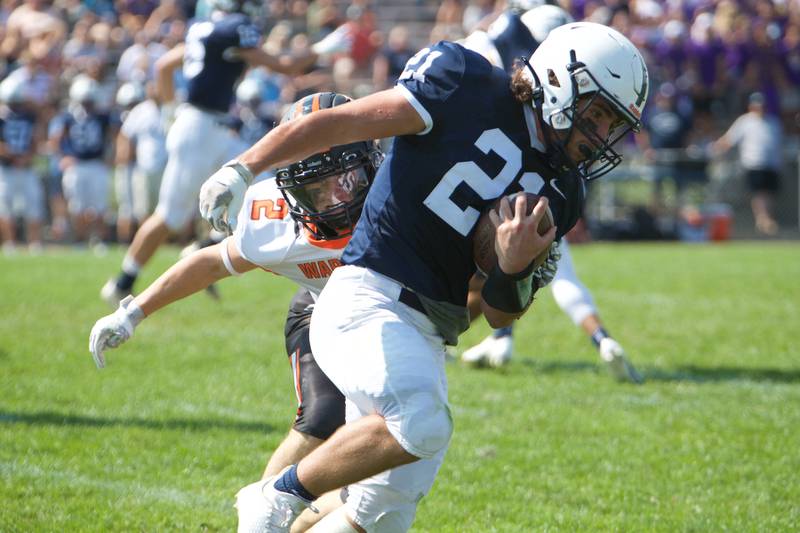 Cary-Grove's Mykal Kannelakis looks to avoid the tackle by McHenry's James LaRose on Saturday, Sept. 17,2022 in Cary.