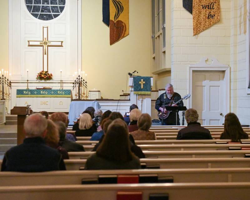 Joe Jencks sings and plays "Jerusalem" by Steve Earle on guitar during a prayer vigil for peace in Israel and Palestine on Tuesday, Nov. 21, 2023, at the First Congregational United Church of Christ in DeKalb.