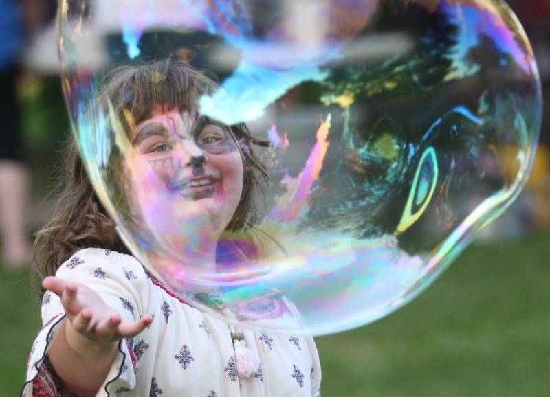 Ame Kuhnert smiles while blowing giant bubbles during the National Night Out event on Tuesday, Aug. 5, 2025 at Zearing Park in Princeton. The event featured K-9 and drone demonstrations, Mr. Cinnamon ballon twister, face painting, emergency vehicles, and more. National Night Out is an annual community policing campaign held on the first Tuesday of August to create police-community partnerships and build safer neighborhoods.