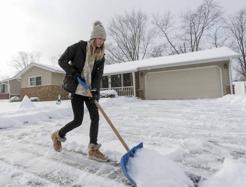 Katherine Neal shovels snow from her driveway in Downers Grove on Monday, Jan. 24, 2022.