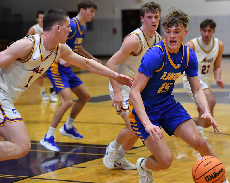 Lyons Township’s Lyons Township’s Timmy Sloan (15) drives as Downers Grove North’s Colin Doyle (left) defends during a game on January 15, 2026 at Downers Grove North High School in Downers Grove .